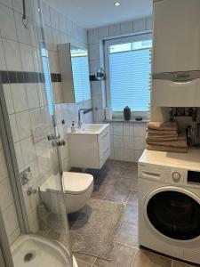 La salle de bains est pourvue de toilettes et d'un lave-linge. dans l'établissement Kassel Apartment am Entenanger, à Cassel