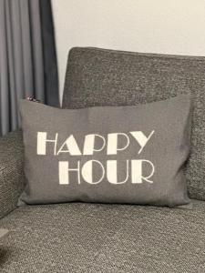 a happy hour pillow sitting on a couch at Kassel Apartment am Entenanger in Kassel