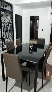 a black dining room table with chairs and a mirror at Lidxi Stagabeñe in Juchitán de Zaragoza