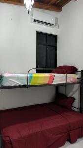 Ce lit superposé se trouve dans un dortoir doté d'un lit rouge. dans l'établissement Lidxi Stagabeñe, à Juchitán de Zaragoza