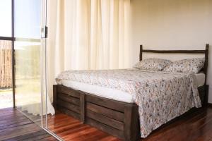 um quarto com uma cama e uma porta de vidro em Dolaço na Chapada- Hospedagem em Alto Paraíso de Goiás