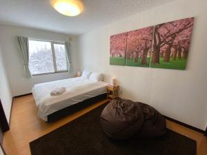 a bedroom with a bed and a large painting on the wall at Yotei Chalets in Niseko