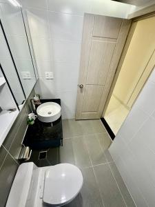 Baño blanco con aseo y lavamanos en Scenic Valley Suite en Ho Chi Minh