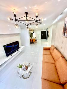 a living room with a couch and a tv at Scenic Valley Suite in Ho Chi Minh City