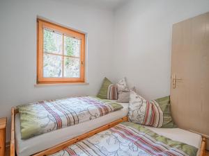 1 dormitorio con 2 camas y ventana en Apartment Leiter, en Bramberg am Wildkogel