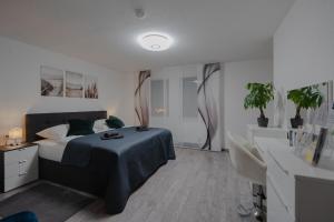 1 dormitorio con 1 cama y escritorio con plantas en Modern - ruhige Lage - zentrumsnah - 2-Zimmer Apartment, en Horb am Neckar