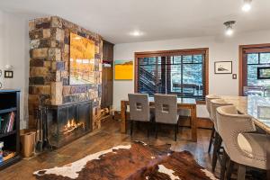 a living room with a fireplace and a table and chairs at Fasching Haus 250, Cozy and Convenient 1 Bedroom, 2 Blocks from Aspen in Aspen