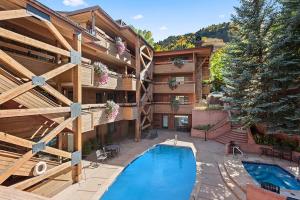a hotel with a swimming pool in front of a building at Fasching Haus 250, Cozy and Convenient 1 Bedroom, 2 Blocks from Aspen in Aspen