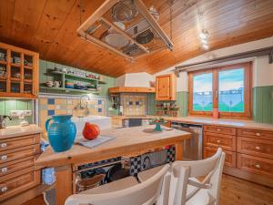 a kitchen with wooden cabinets and a counter with chairs at Panoramahaus Itter in Itter