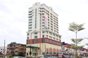a tall white building on the corner of a street at Summit Signature Hotel Batu Pahat in Batu Pahat