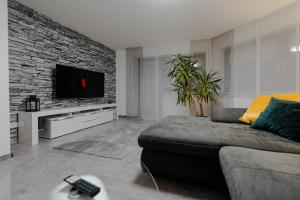 uma sala de estar com um sofá e uma televisão de ecrã plano em Modern - ruhige Lage - zentrumsnah - 2-Zimmer Apartment em Horb am Neckar