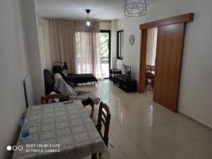 een woonkamer met een tafel en een bank bij St. Lazaros Seaside Apartment in Larnaka