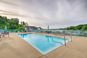 a large swimming pool with chairs and tables at Condo with Balcony and Views in Lake of the Ozarks in Lake Ozark