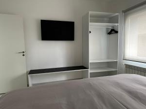a bedroom with a bed and a tv on the wall at Urbano Esquel in Esquel