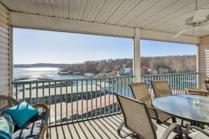 a balcony with a table and chairs and a view of the water at Condo with Balcony and Views in Lake of the Ozarks in Lake Ozark