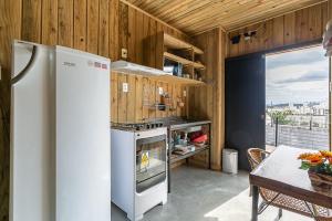a kitchen with a white refrigerator and a table with a tableablish at Casa Completa com Excelente Localização in Florianópolis