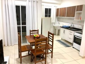 uma cozinha com mesa e cadeiras e uma cozinha com lavatório em Apartamento Privado - 2 quartos, varanda, sala e cozinha integrada em Piracicaba