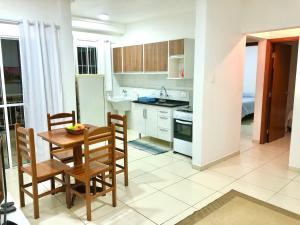 uma cozinha com mesa e cadeiras num quarto em Apartamento Privado - 2 quartos, varanda, sala e cozinha integrada em Piracicaba