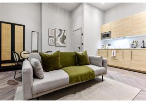 a living room with a couch with green pillows at Charming 1BR Oasis in the Heart of Clapton Common in London