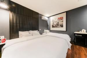 sypialnia z dużym białym łóżkiem w pokoju w obiekcie 2 Heaven Hotel Songdo w Pusanie