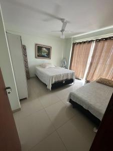 a bedroom with two beds and a window at Apartamento frente ao mar in Saquarema