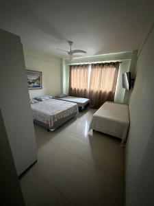 a bedroom with two beds and a window at Apartamento frente ao mar in Saquarema