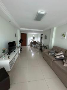 a large living room with a couch and a tv at Apartamento frente ao mar in Saquarema