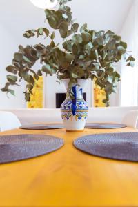 een blauwe en witte vaas op een tafel met een plant bij Casa La Platería in Córdoba