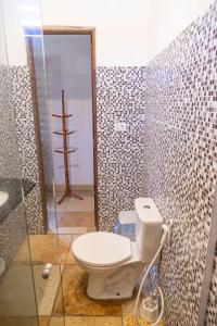 a bathroom with a toilet and a glass wall at Casa da Juma in Fortim