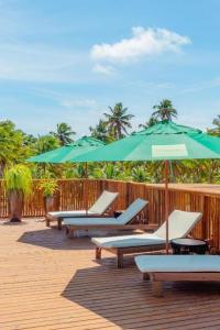 un groupe de chaises et de parasols sur une terrasse dans l'établissement Studio Beira Mar de Tatuamunha, Rota dos Milagres, à Porto de Pedras 17 autres photos