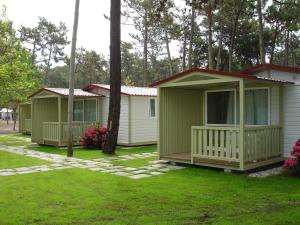 una fila de casas móviles verdes en un patio en Parque de Campismo Orbitur Mira, en Praia de Mira