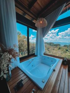 a bath tub in a room with windows at Cabanas Urubici in Urubici