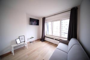 a living room with a couch and a large window at Smart Appart - City Center Liege in Liège