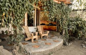 two chairs and a table in front of a house at Bambuddha - Garden Suite at Lakehouse in San Pedro La Laguna