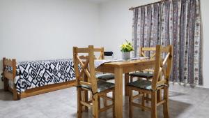 聖拉斐爾的住宿－Oasis Urbano 2，一张木桌、两把椅子和一张床
