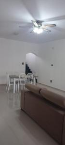 a living room with a ceiling fan and a table and chairs at Casa Temporada em Aparecida com vista para Basílica in Aparecida