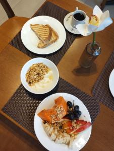 - une table avec des assiettes de produits pour le petit-déjeuner dans l'établissement GoÁtica Aeroporto Congonhas, à São Paulo