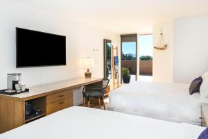 1 Schlafzimmer mit 2 Betten und einem Schreibtisch mit einem TV in der Unterkunft Sky Rock Sedona, a Tribute Portfolio Hotel in Sedona