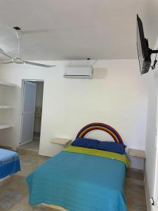 a bedroom with a bed with a rainbow colored blanket at Hotel Tamarindos in Zihuatanejo