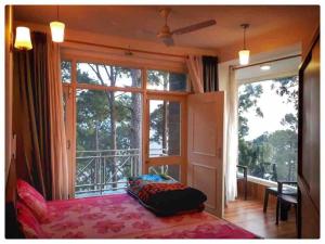 a bedroom with a bed and a large window at Modern 2 bedroom apartment Near Nainital and Kaichi Dham SF4 in Nainital