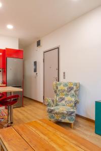 uma sala de estar com uma cadeira e uma mesa em Academia apartments by the park em Atenas