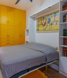 a small bedroom with yellow cabinets and a bed at Academia apartments by the park in Athens