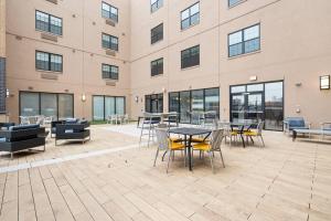 a patio with tables and chairs in front of a building at Urban Luxury Condo: 20 Mins to NYC (Gym, Laundry) in Jersey City