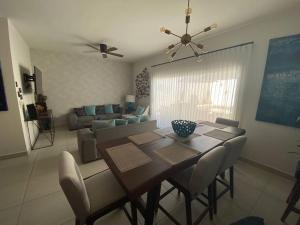 a dining room table with chairs and a living room at Casa Completa con Alberca privada in La Paz