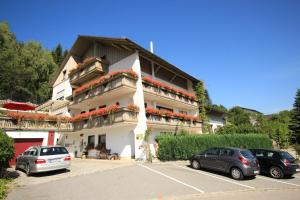 a building with cars parked in a parking lot at Haus Margarete & Landhaus Karin in Zwiesel