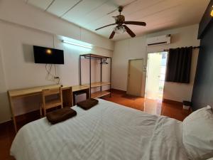 Schlafzimmer mit einem weißen Bett und einem Deckenventilator in der Unterkunft ศิริภูมิอพาร์ทเม้น ซอย.9 in Ban Lat Krachaeng