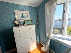 a bedroom with blue walls and a dresser with a window at Salt Pond Sunrise View & 5 min to beach, sleeps 7 in Charlestown
