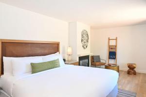 a bedroom with a large white bed and a fireplace at Sky Rock Sedona, a Tribute Portfolio Hotel in Sedona