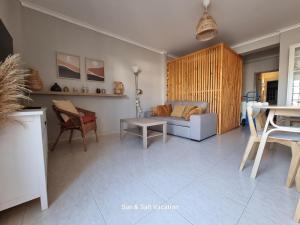 a living room with a couch and a table at Casa da Praia, Cabanas de Tavira, Cute T2 around the corner to the water front in Cabanas de Tavira