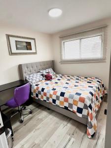 a bedroom with a bed and a desk and a chair at Main floor Room with Queen Bed, Free Parking and Free wi-fi and shared washroom near Fairview Park Mall (Room 2) in Kitchener